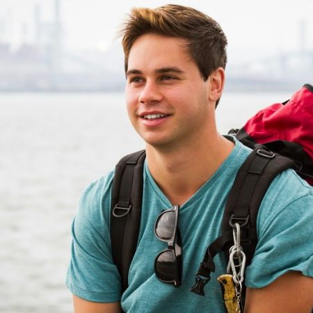 jesse carrying his back pack sitting on the seas shore 